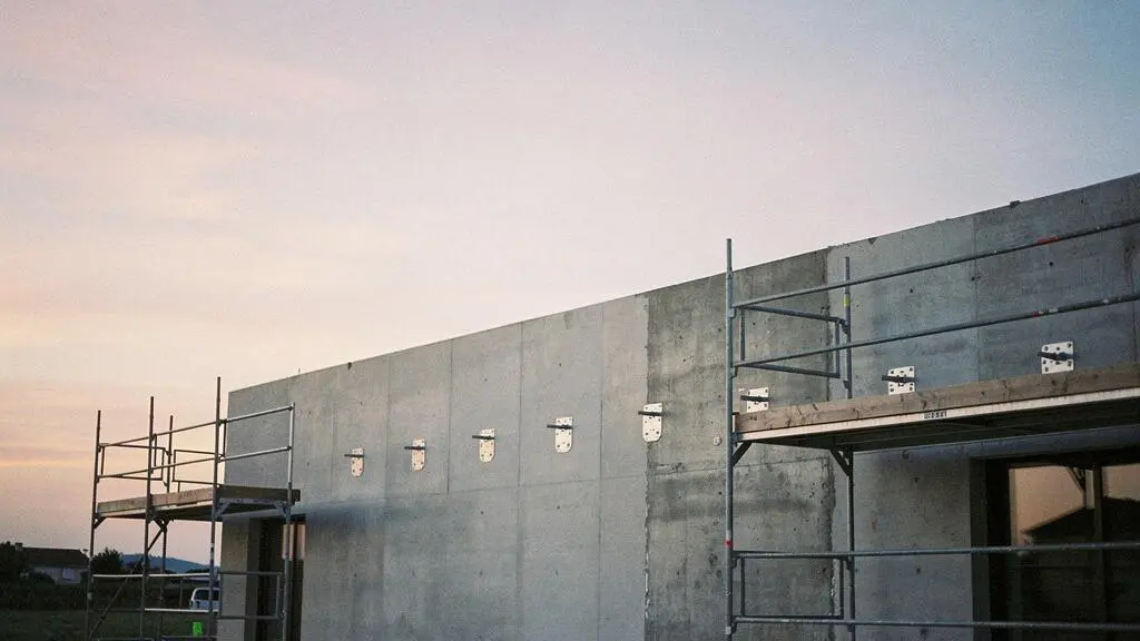 Facade d'une maison neuve francaise en cours de construction avec points d'ancrage prevus avant la pose de l'enduit