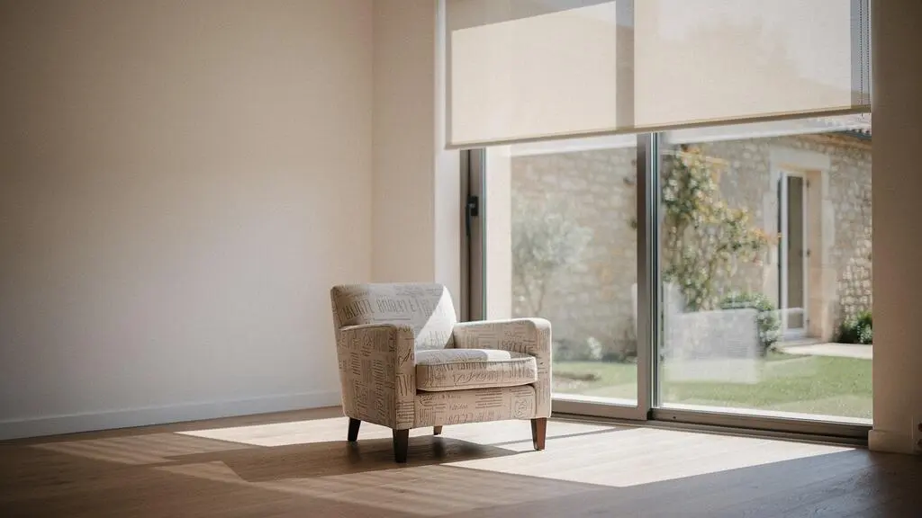 Salon baigné de lumière naturelle douce grâce à une protection solaire extérieure sur une baie vitrée, sans éblouissement