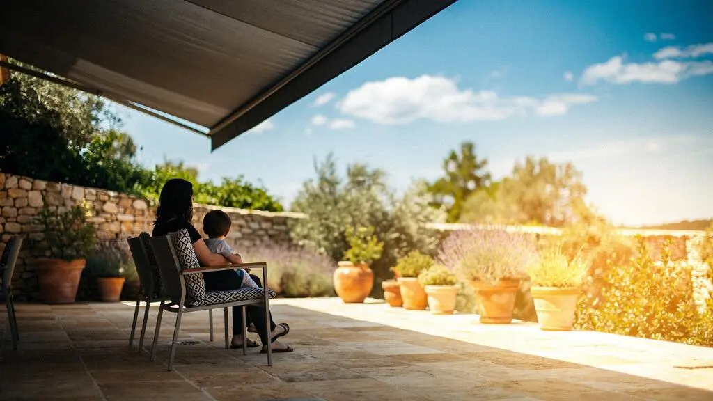 Famille profitant d'une terrasse ombragée par un store banne sous le soleil français