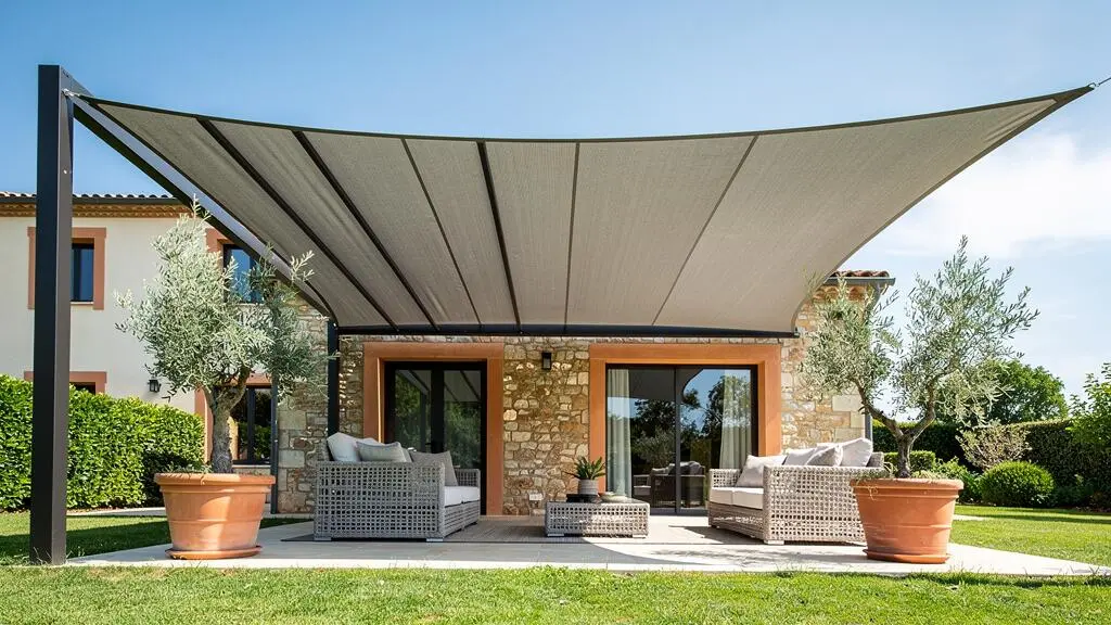 Terrasse française entièrement ombragée toute la journée grâce à une combinaison de pergola, store banne et voile d'ombrage